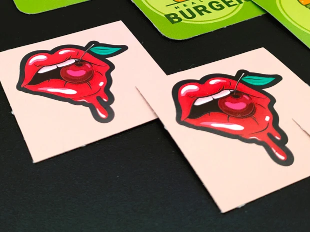 Custom adhesive stickers - Graphic design. Red lips with a hanging cherry on a light background.