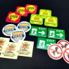 Custom printed adhesive stickers - graphic design. Includes text, symbols, and various shapes.