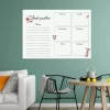 Weekly planner dry-erase board with floral design, styled in a green wall living room with black furniture accents.