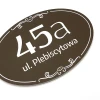 Address plaque, house number - Graphic design. Oval shape, brown background, white numbers and text.