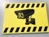 Camera sign - Graphic design. Yellow background with a black camera icon and warning stripes.