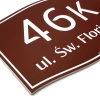 Address plaque with graphic design. Rectangular sign featuring white letters on a brown background.