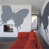 Elegant gray butterfly sticker, perfect for a modern living room with an orange sofa.