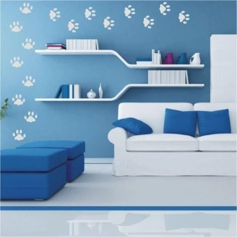 Fresh white cat paw prints on a blue wall in a modern living room, adding charm and character.