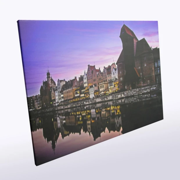 Canvas print 30x40 cm - Cityscape. View of buildings by the river in twilight light.