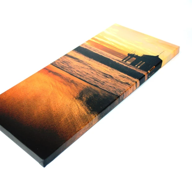 Canvas print 60x90 cm - Graphic design featuring a sunset over the sea with a pier.