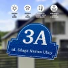 Round address plaque for home or fence, featuring a graphic design with blue background and white letters.