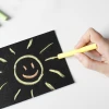 Chalkboard film - black - with a graphic design of a smiling sun and rays on the surface.