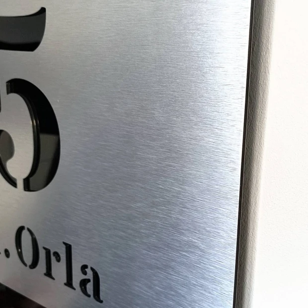 Engraved address plaque in brushed silver and black dibond, 42 x 35 cm, with a graphic design and cut-out front.