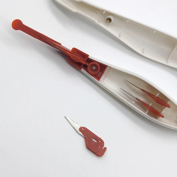Safe media cutting knife - Graphic design. Knife with white casing, red handle, and blade.