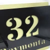 Engraved address plaque in black and gold dibond, 42 x 35 cm, featuring cut-out letters revealing the background.