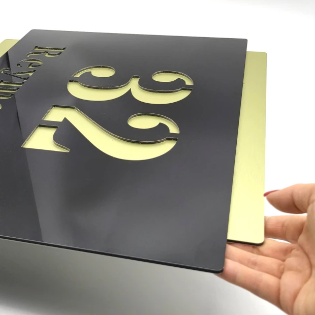 Engraved address plaque in dibond 42 x 35 cm black and gold - Graphic design. Black letters cut in the shape of numbers.