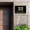 Engraved address plaque in black and gold dibond, 42 x 35 cm - Styled in a modern setting with a gradient wall.