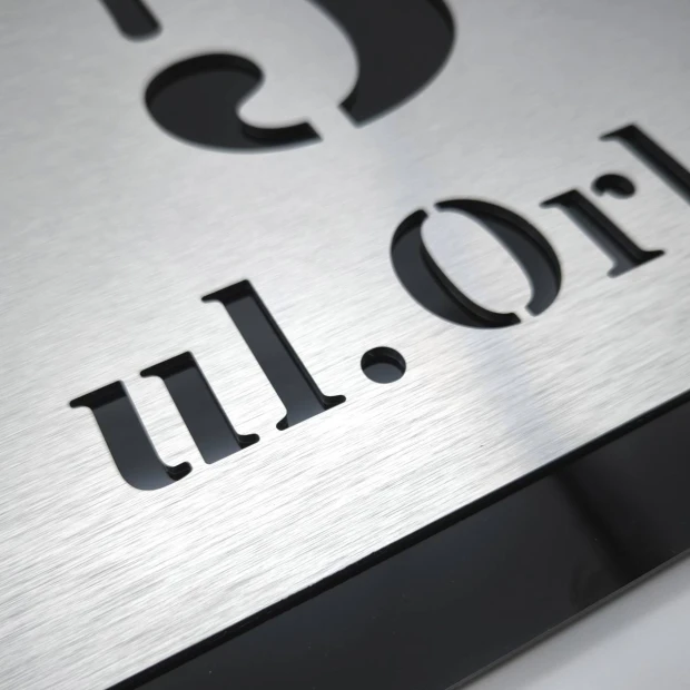 Engraved address plaque in brushed silver and black dibond, 42 x 35 cm, featuring a graphic design.