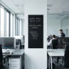 Custom chalkboard - chalk markers - Office decor. Light-colored walls, gray furniture.