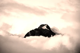 Wallpaper A Mountain Peak Surrounded By Clouds Fp 3715
