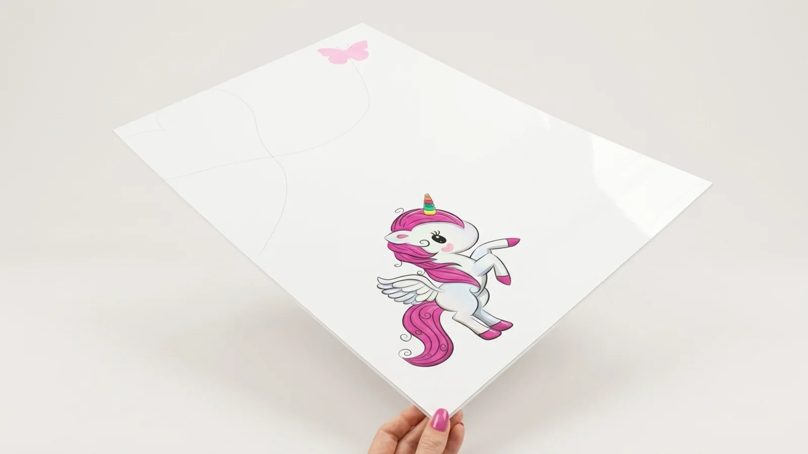 A hand holding a white whiteboard with a unicorn