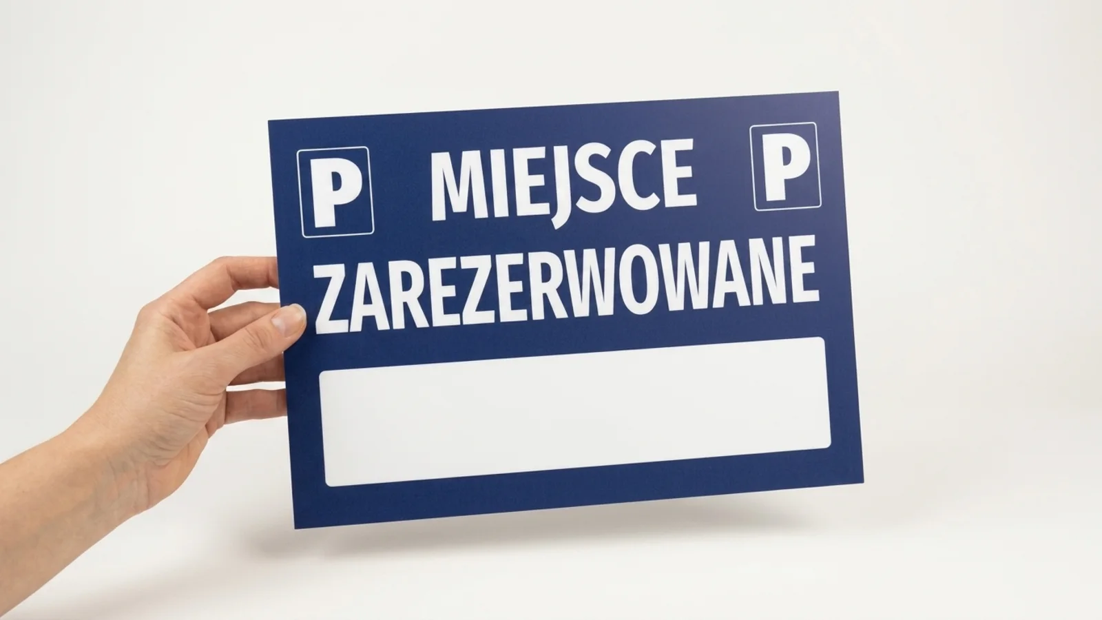 A hand holding a navy parking sign reading Reserved space
